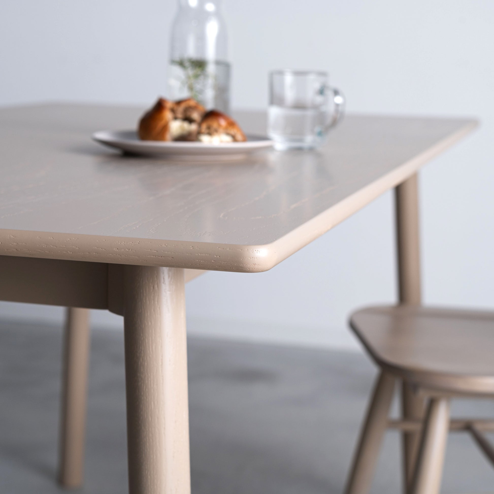 天然木オーク材を天板と脚部に使用しウレタン塗装でグレーに塗られたワントーンデザインのダイニングテーブルの天板のアップ