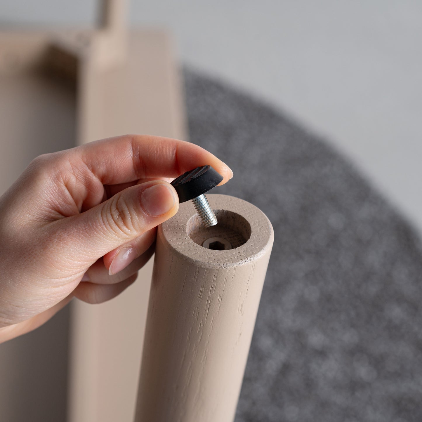 天然木オーク材を天板と脚部に使用しウレタン塗装でグレーに塗られたワントーンデザインのダイニングテーブルの足裏のアジャスターの写真