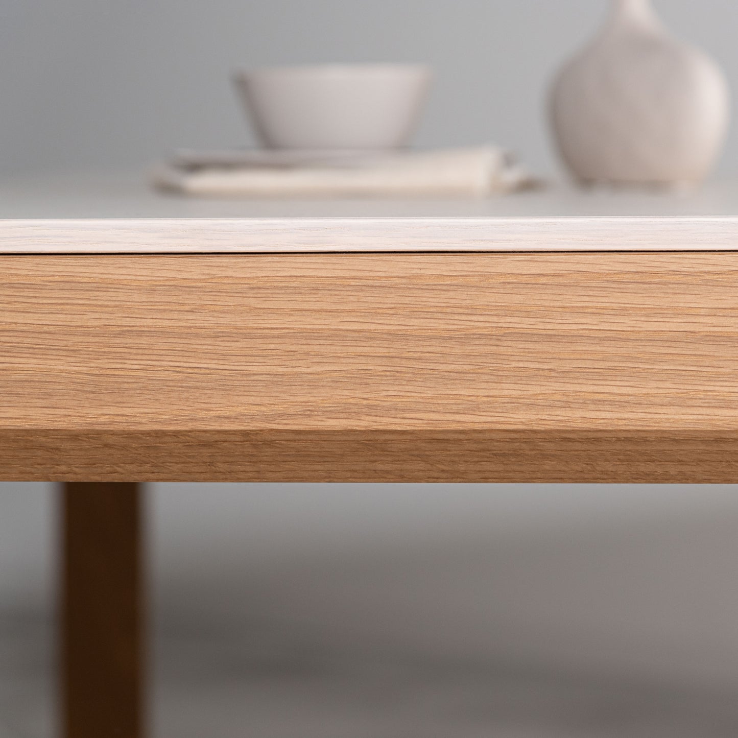 大理石調の天板が特徴的な土台は天然木のダイニングテーブルの天板を真横から見た写真