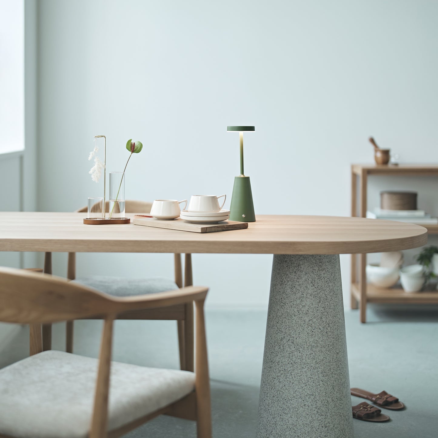 部屋の窓辺で天然木の天板にテラゾー柄のスチール脚を組み合わせた、異素材ミックスデザインのダイニングテーブルと天然木のダイニングチェアを合わせたインテリア