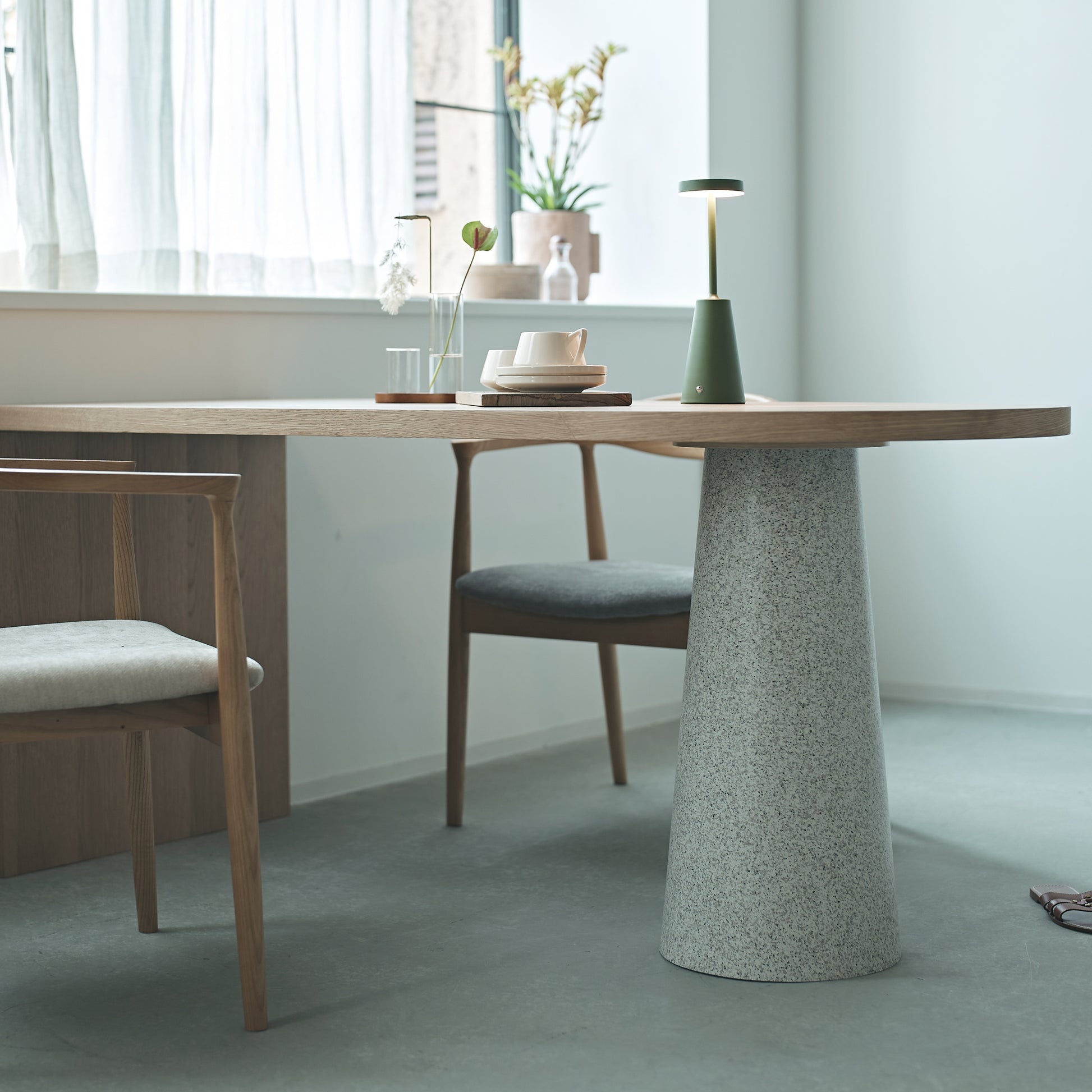 部屋の窓辺で天然木の天板にテラゾー柄のスチール脚を組み合わせた、異素材ミックスデザインのダイニングテーブルと天然木のダイニングチェアを合わせたインテリア