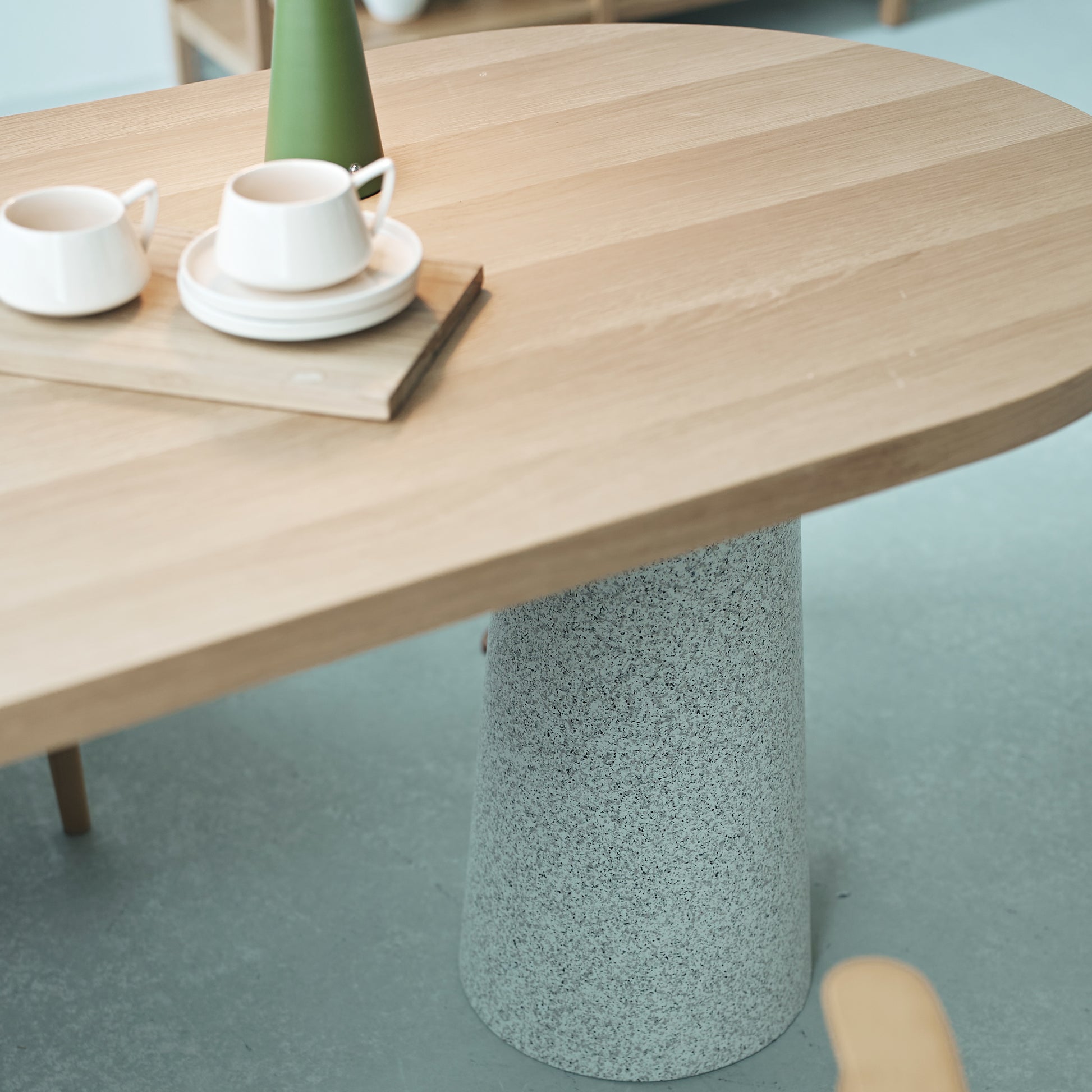 天然木の天板にテラゾー柄のスチール脚を組み合わせた、異素材ミックスデザインのダイニングテーブルの天板のアップ