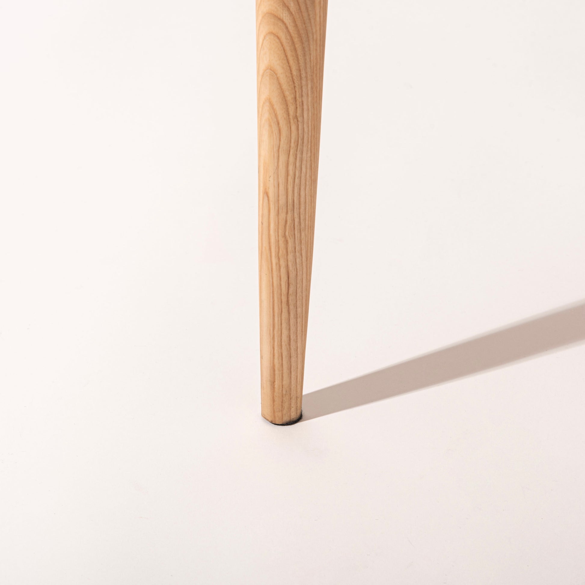 ペーパーコードの座面が特徴のアーム付きチェアの脚部分