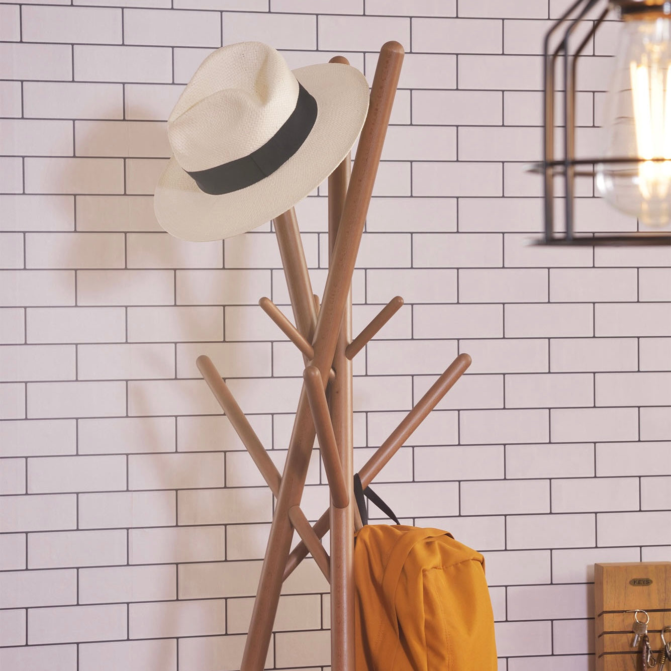 木の枝が交差したようなデザインのハンガーラックに帽子が置かれている様子