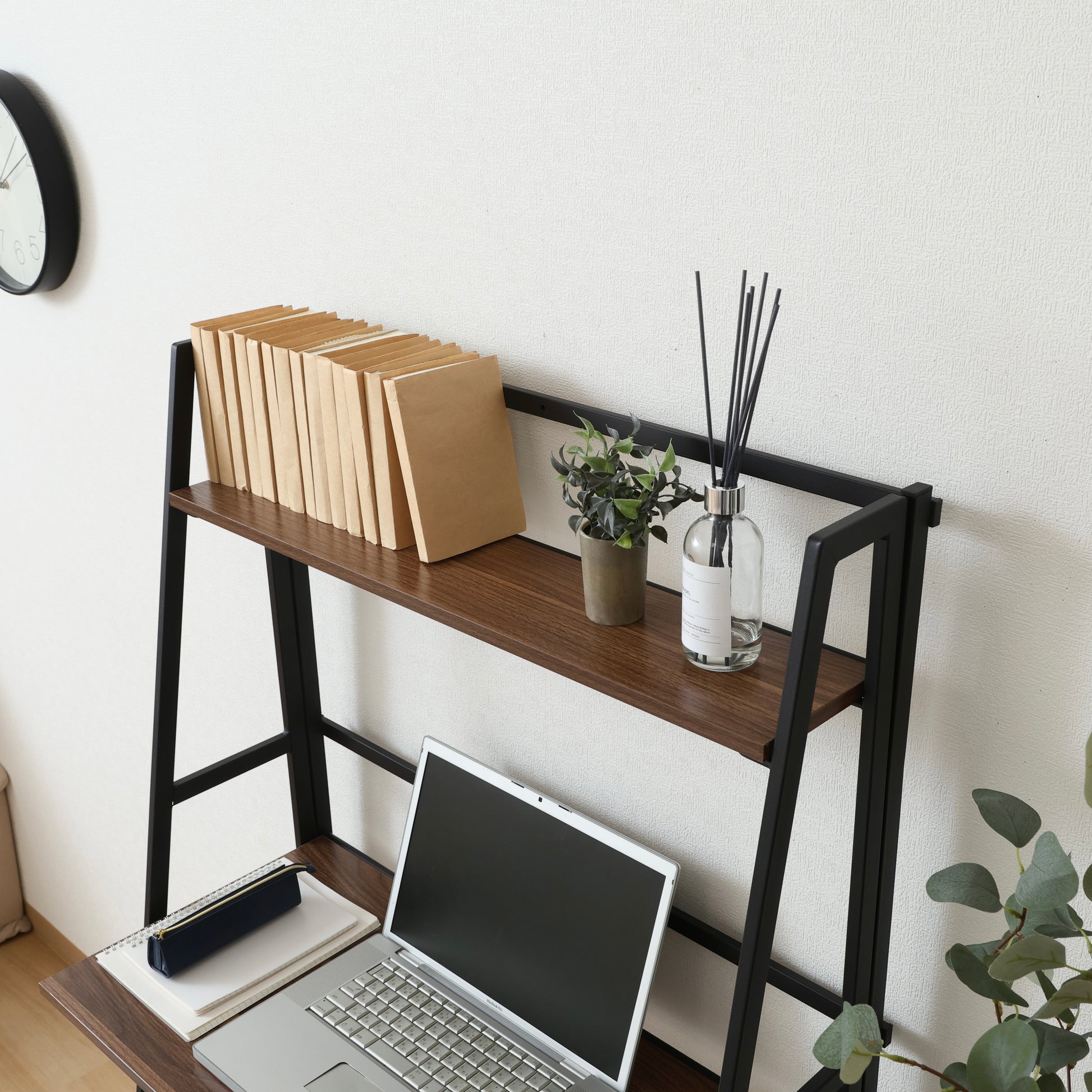 収納棚が付いた折りたたみ式のデスクにパソコンや本が置かれている様子