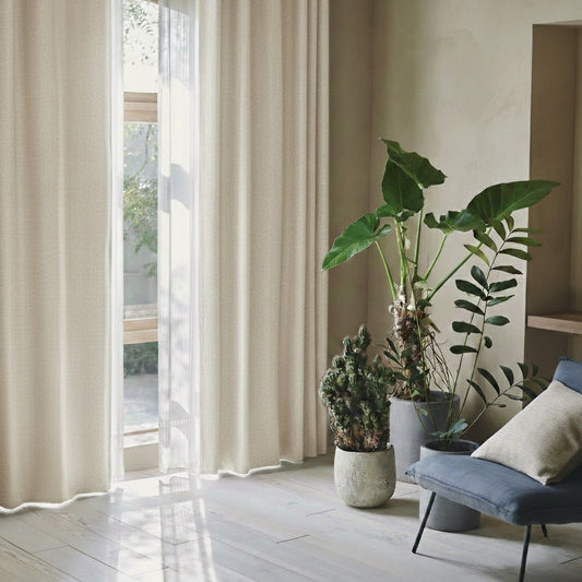 杢調のナチュラルな生地感の遮光1級カーテンが窓にかかった部屋