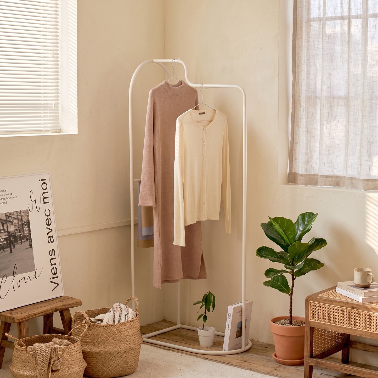 Roomnhomeの白い金属製アーチカーブハンガーに2着の衣服が掛かっています