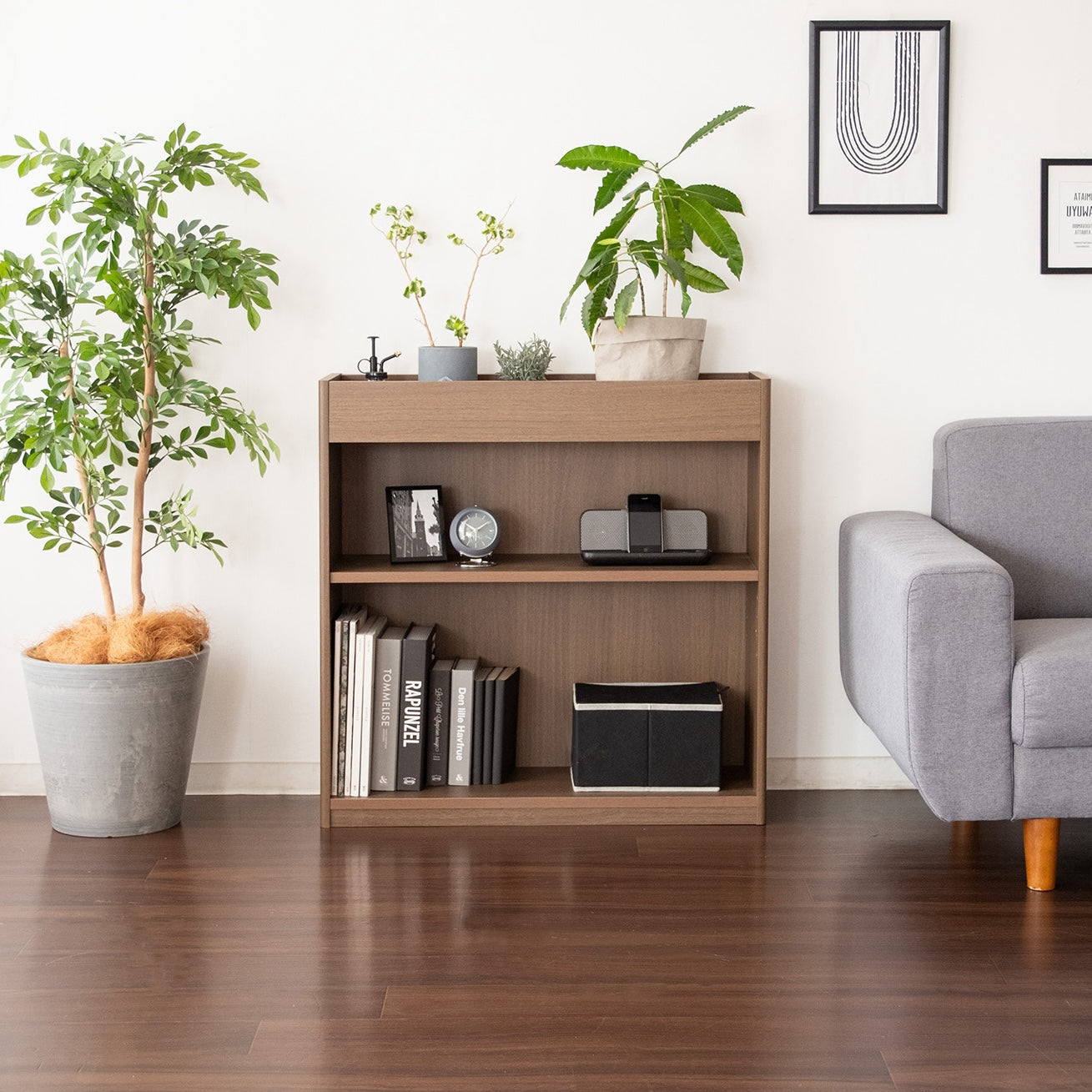 ブラウンの2段のオープンラックに植物と本が収納されている様子