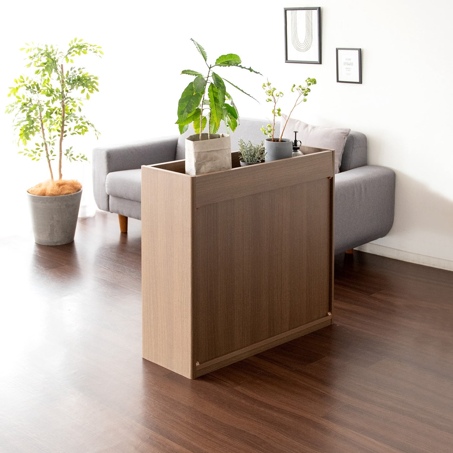 ブラウンの2段のオープンラックに植物と本が収納されている様子