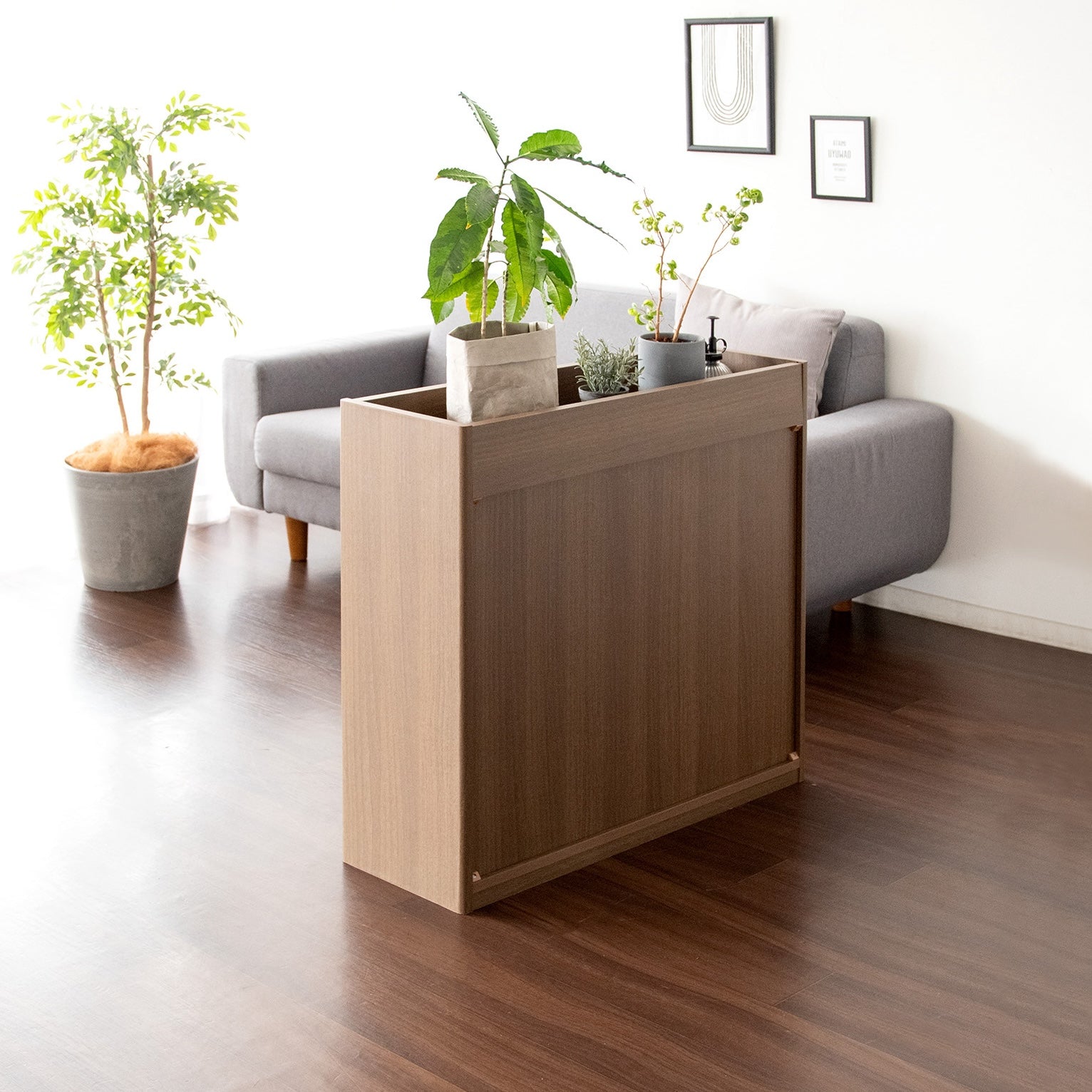 ブラウンの2段のオープンラックに植物と本が収納されている様子