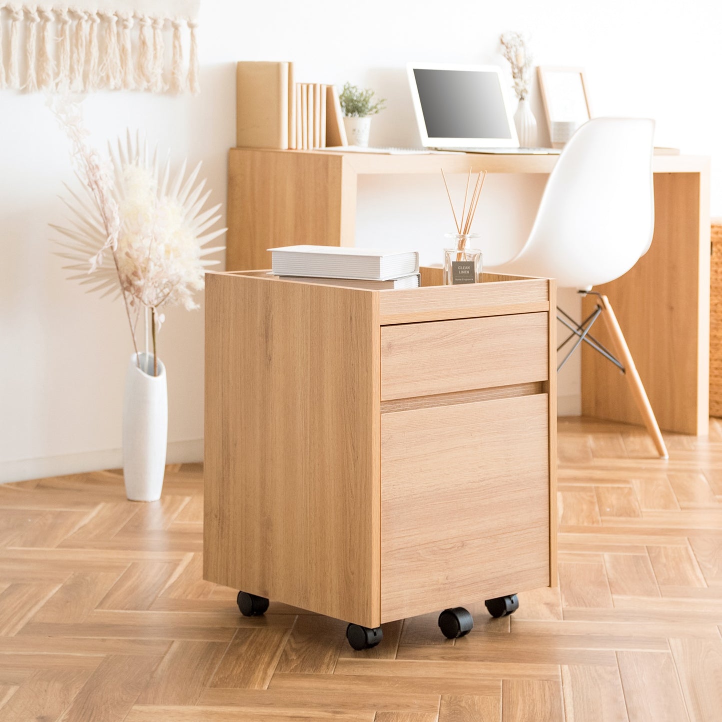 木目調のサイドチェストに本やフレグランスが置かれている様子