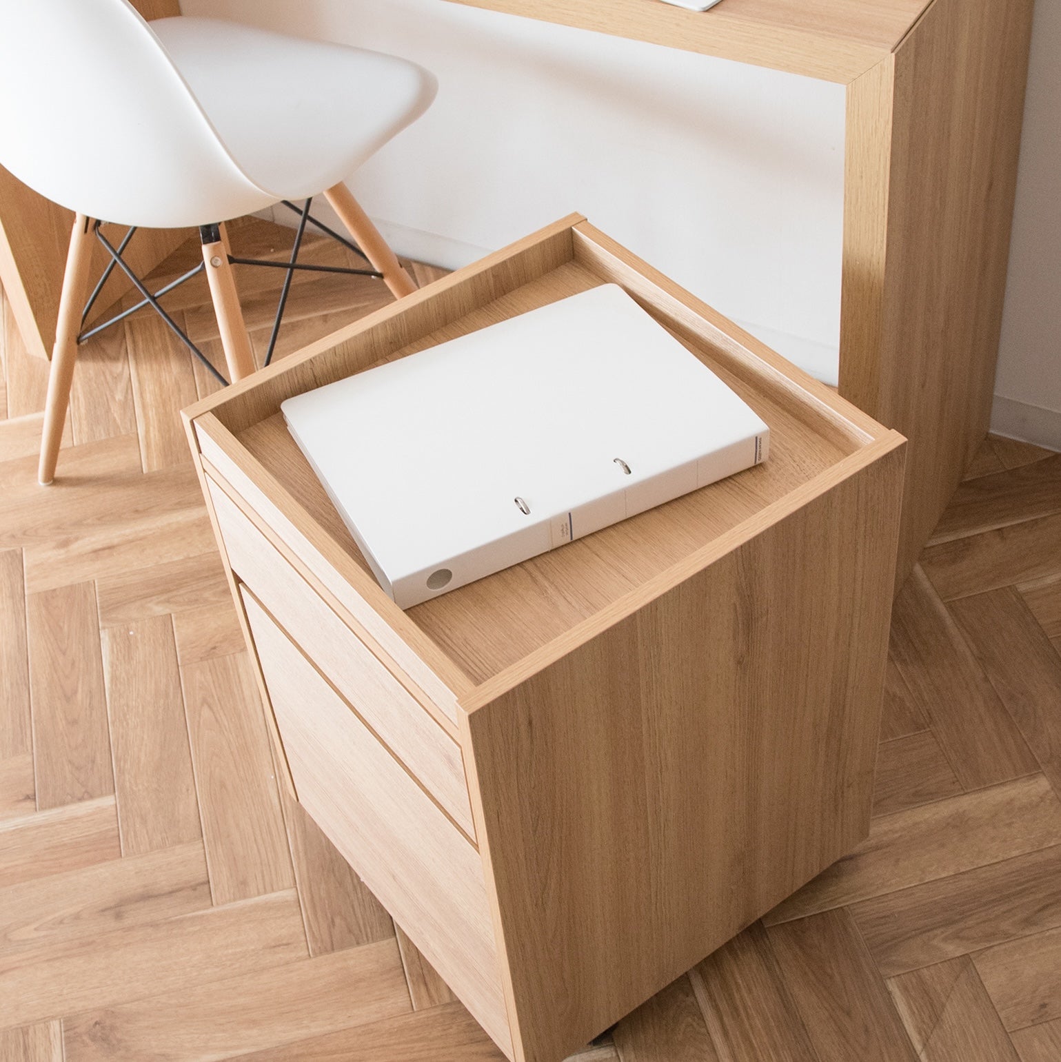 デスク横に置かれた木目調のサイドチェストに書類が置かれている様子