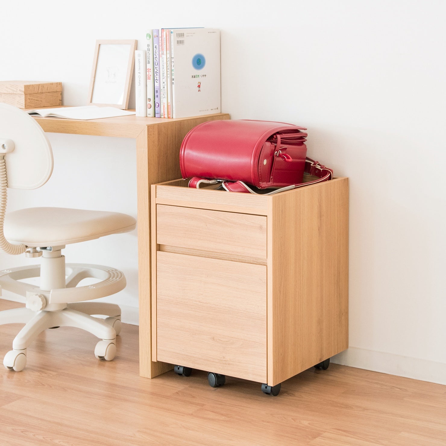 デスク横に置かれた木目調のサイドチェストにランドセルが置かれている様子