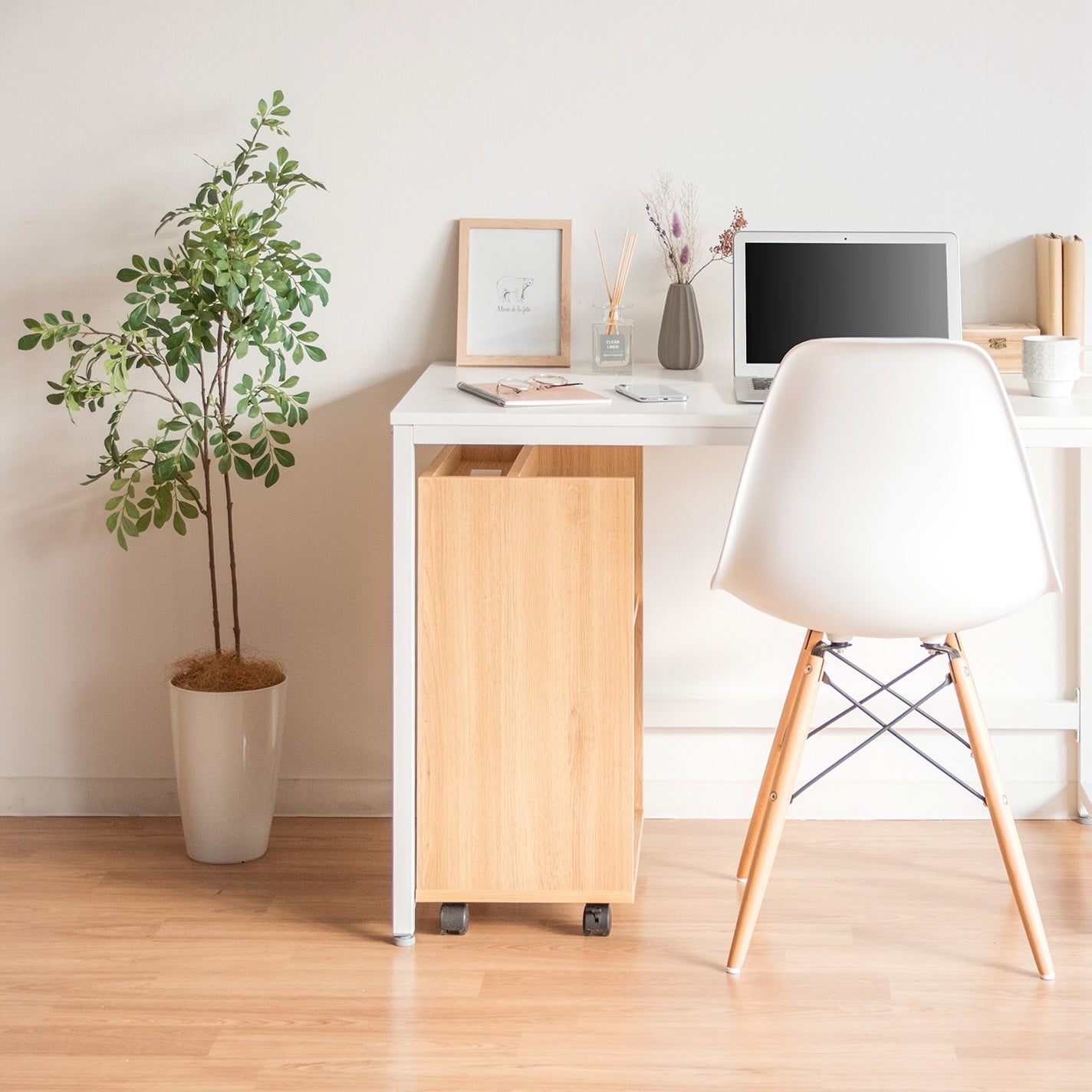 キャスター付きの木目調の2段のラックがデスク下に収納されている様子