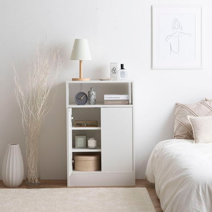 白の扉付きの収納とオープン棚が組み合わさったキャビネットを部屋の中でベッドの横に置いている