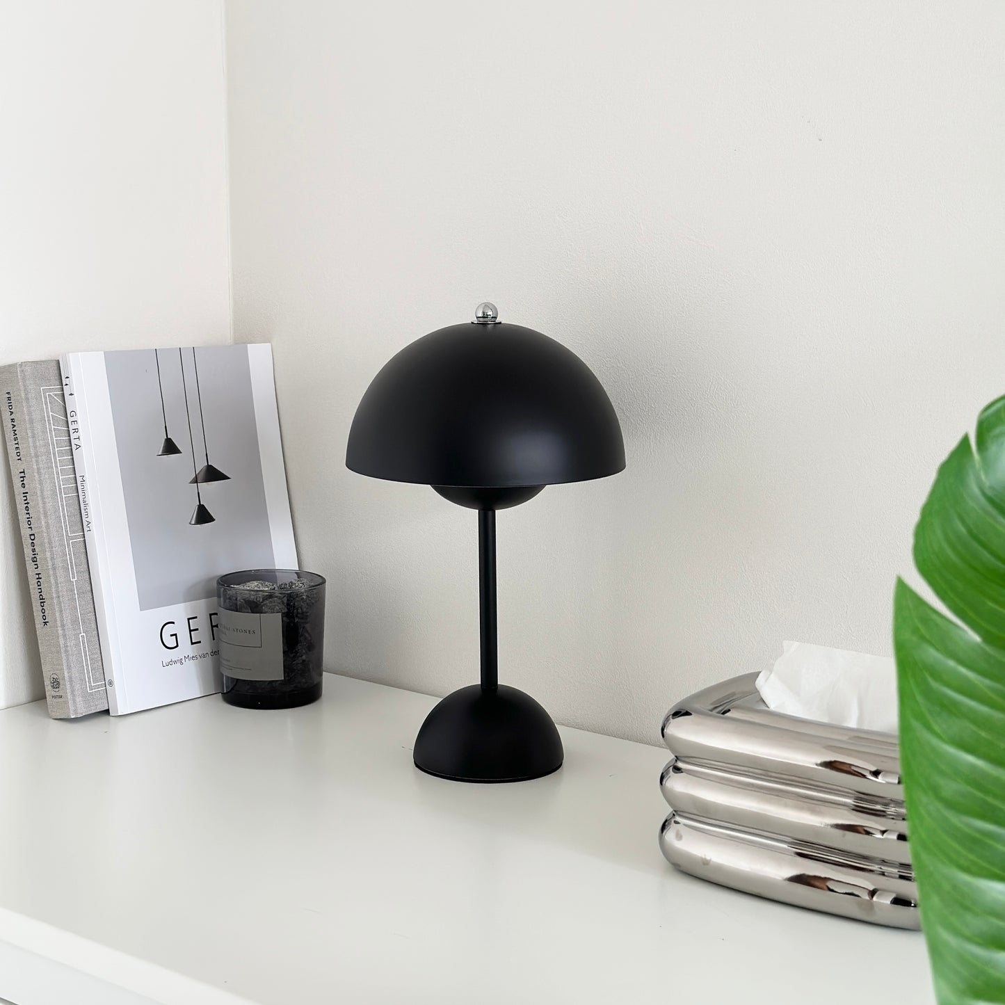 マットな質感のブラックのライトとその横に本が2冊立てかけられている