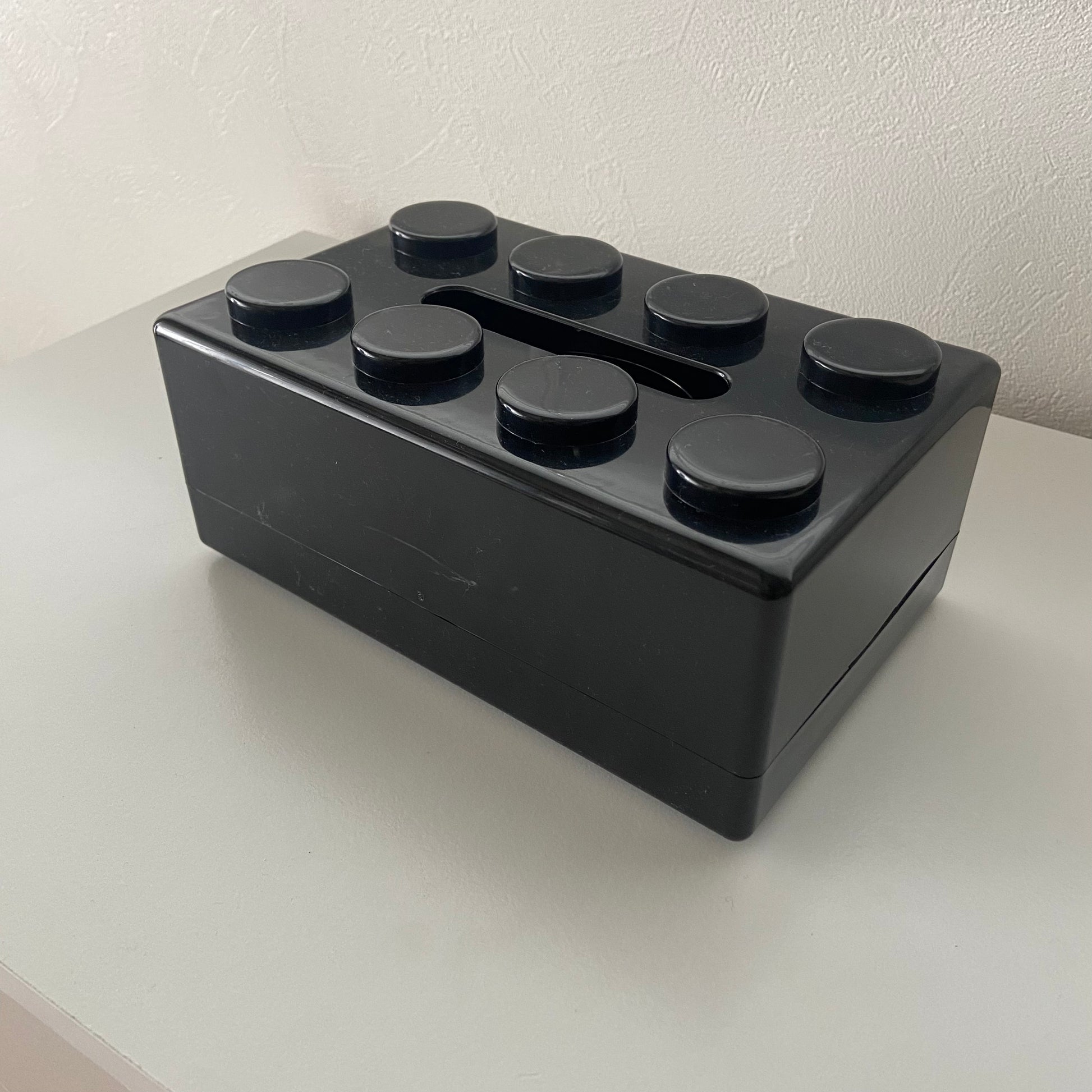 ブラックのブロックデザインのティッシュケースに傷が入っている様子