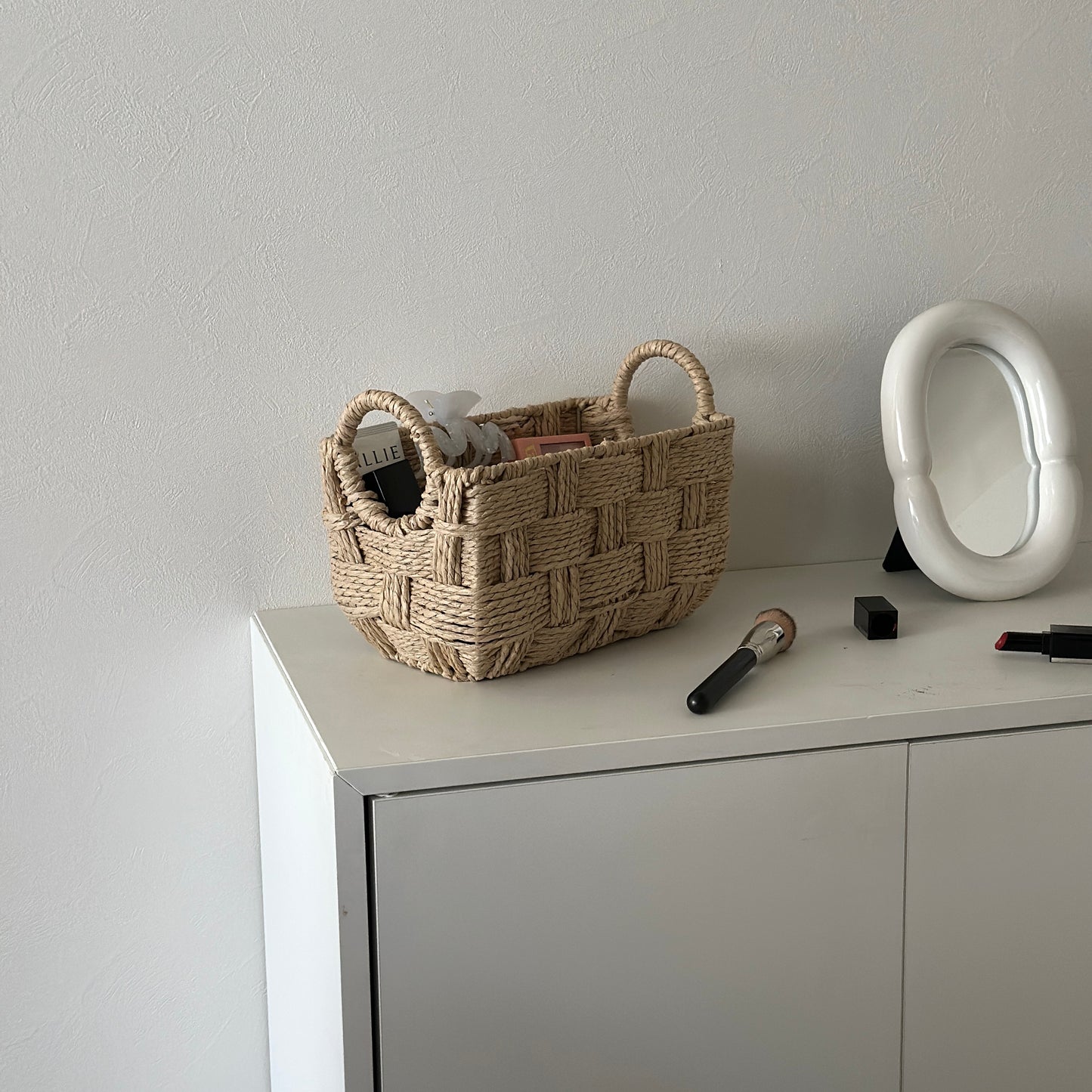 取手がついたロープ編みのバスケットにコスメが収納されている様子