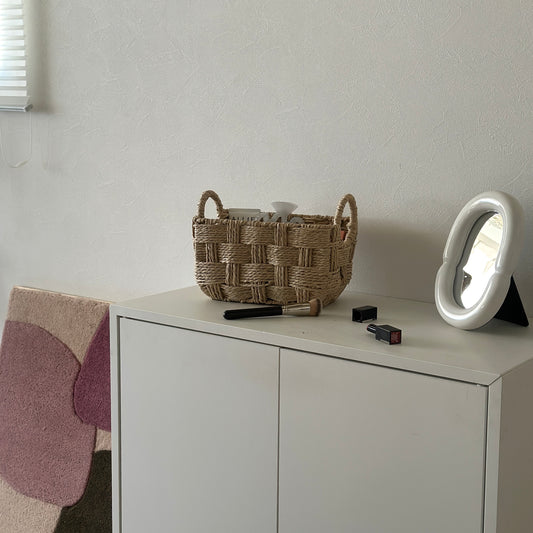 取手がついたロープ編みのバスケットにコスメが収納されている様子