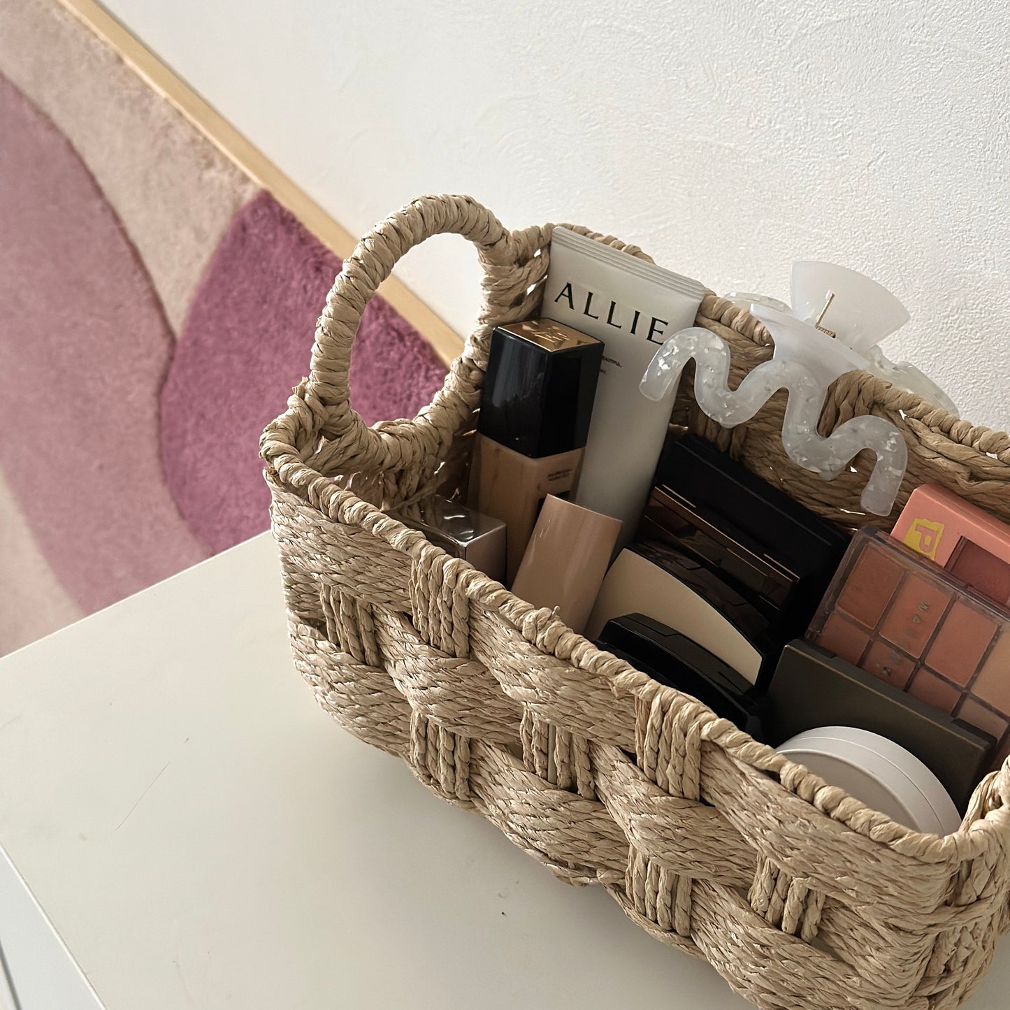 取手がついたロープ編みのバスケットにコスメが収納されている様子