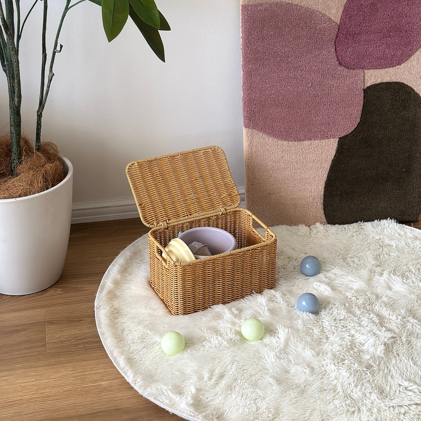 ラタン調のバスケットに子供用のおもちゃを入れている様子