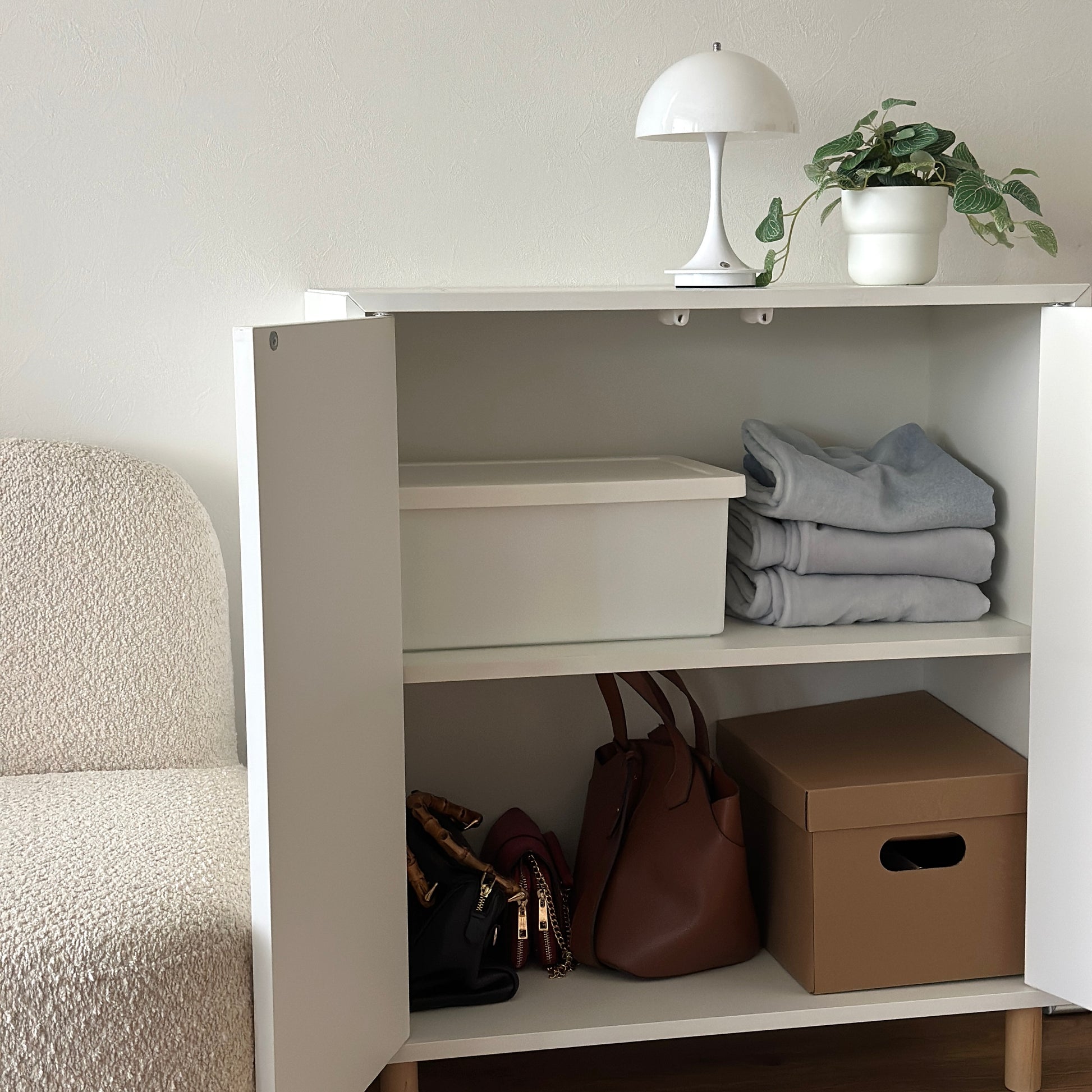 蓋付きのシンプルなプラスチックの収納ボックスが棚の中に収納されている様子