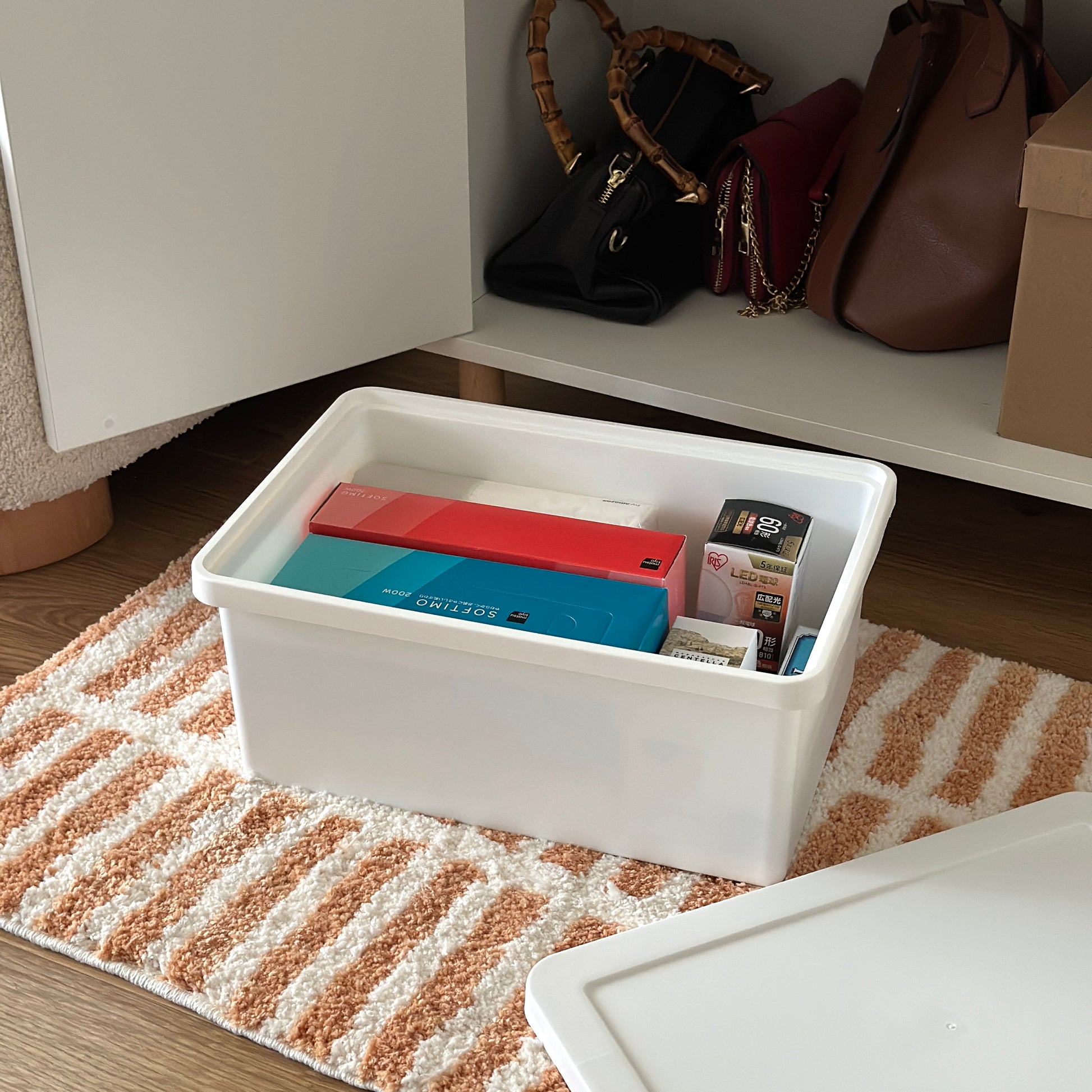 蓋付きのシンプルなプラスチックの収納ボックスにストックアイテムが収納されている様子