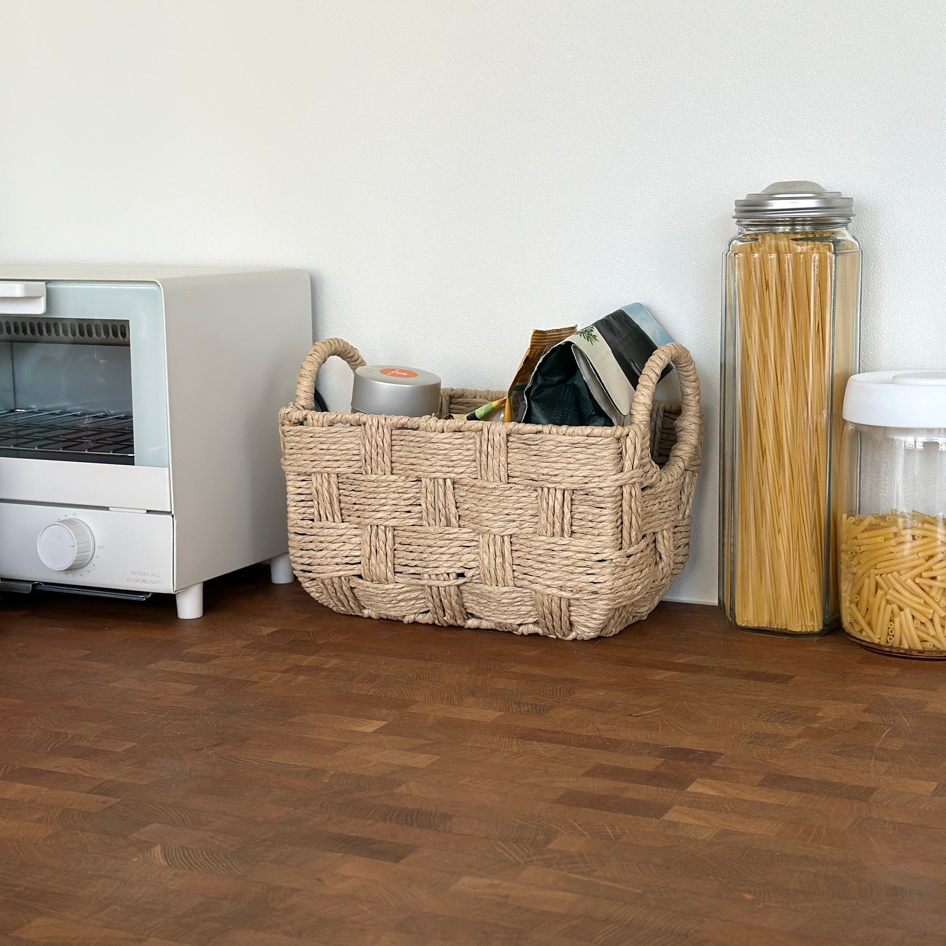 キッチンで取手がついたロープ編みのバスケットにストック品が収納されている様子