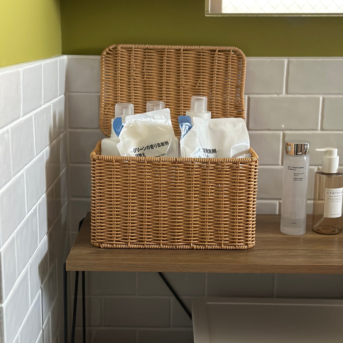 洗面所でラタン調のバスケットに洗剤を入れている様子