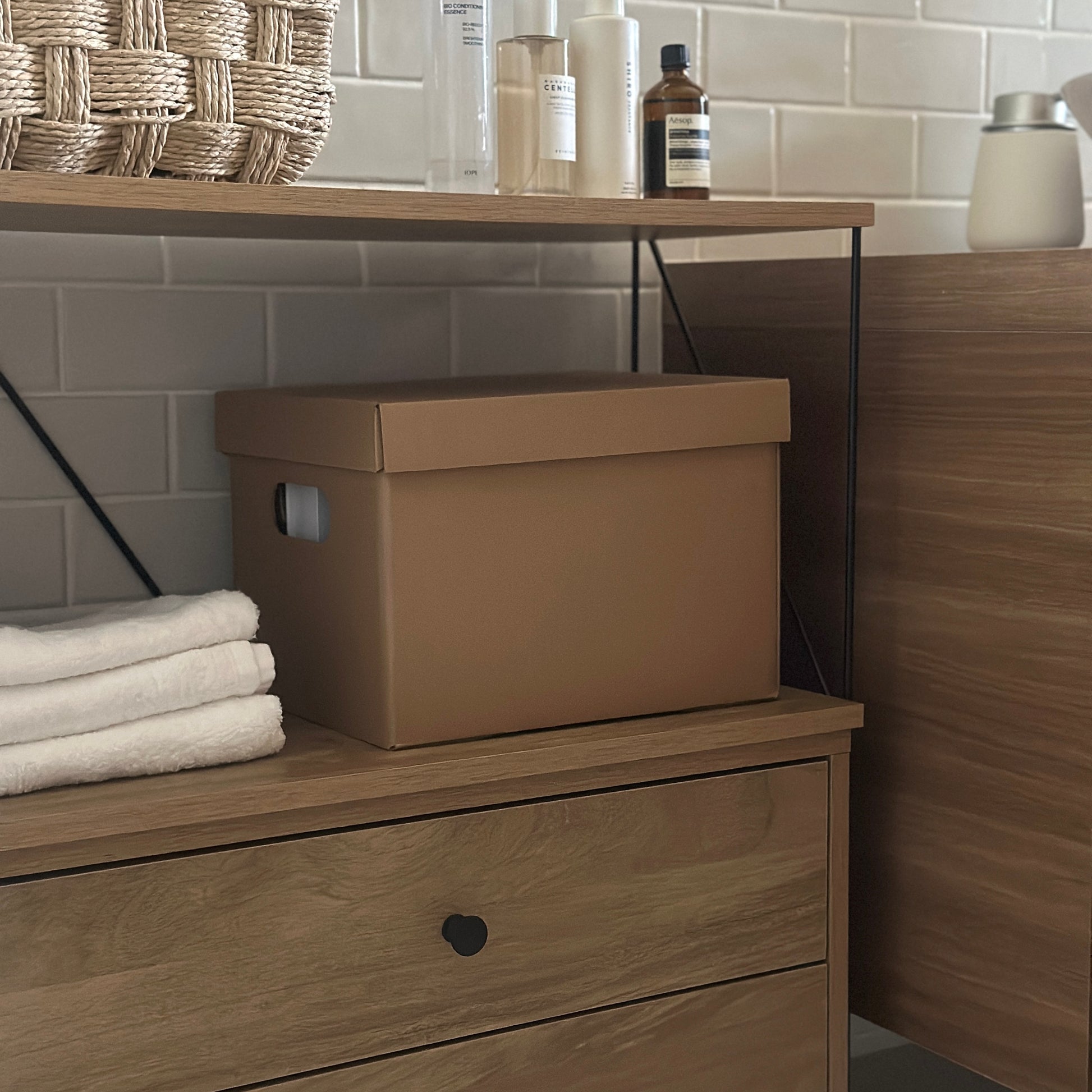 洗面所で蓋付きのクラフトボックスが棚の中に収納されている様子