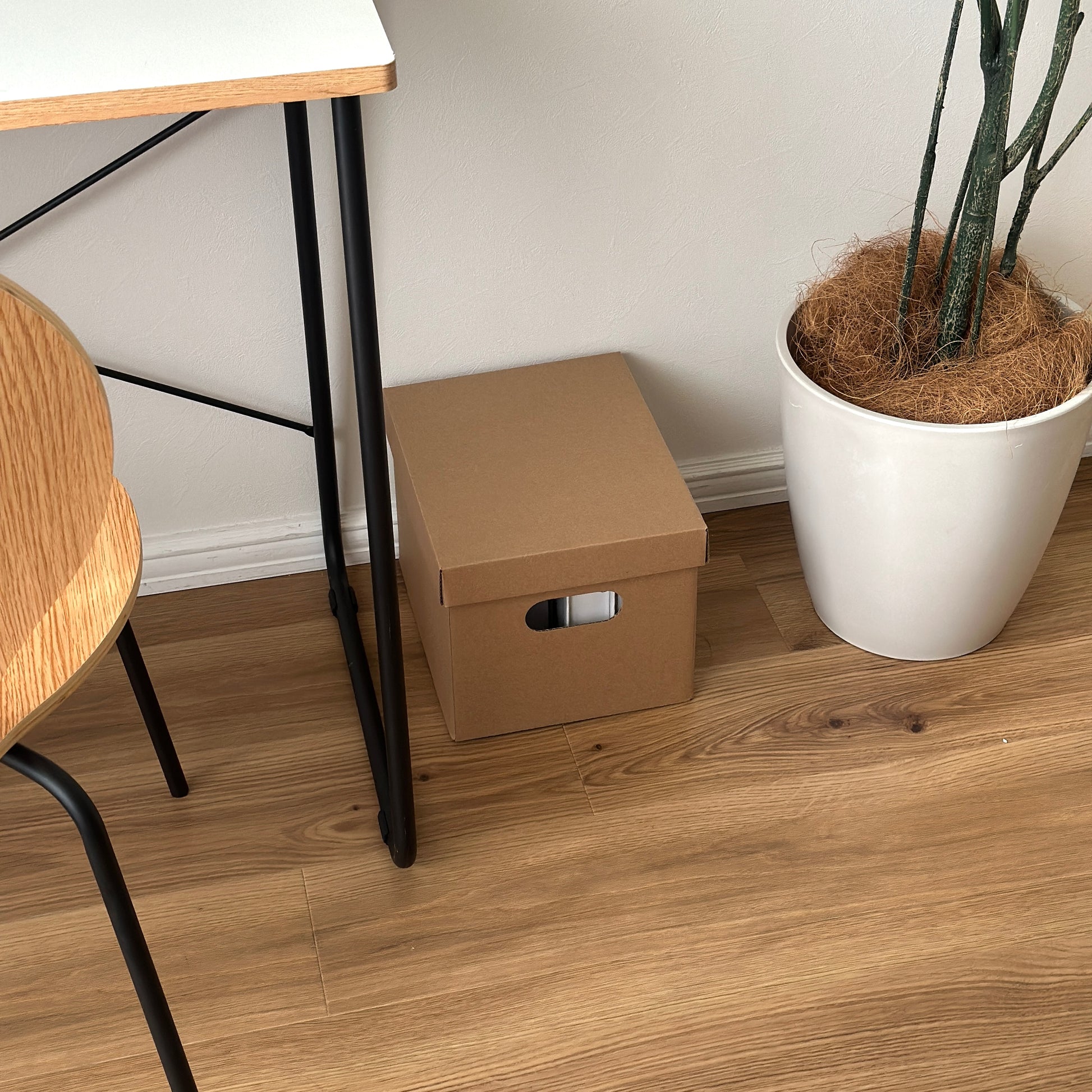 デスクの下に蓋付きのクラフトボックスが置かれている様子