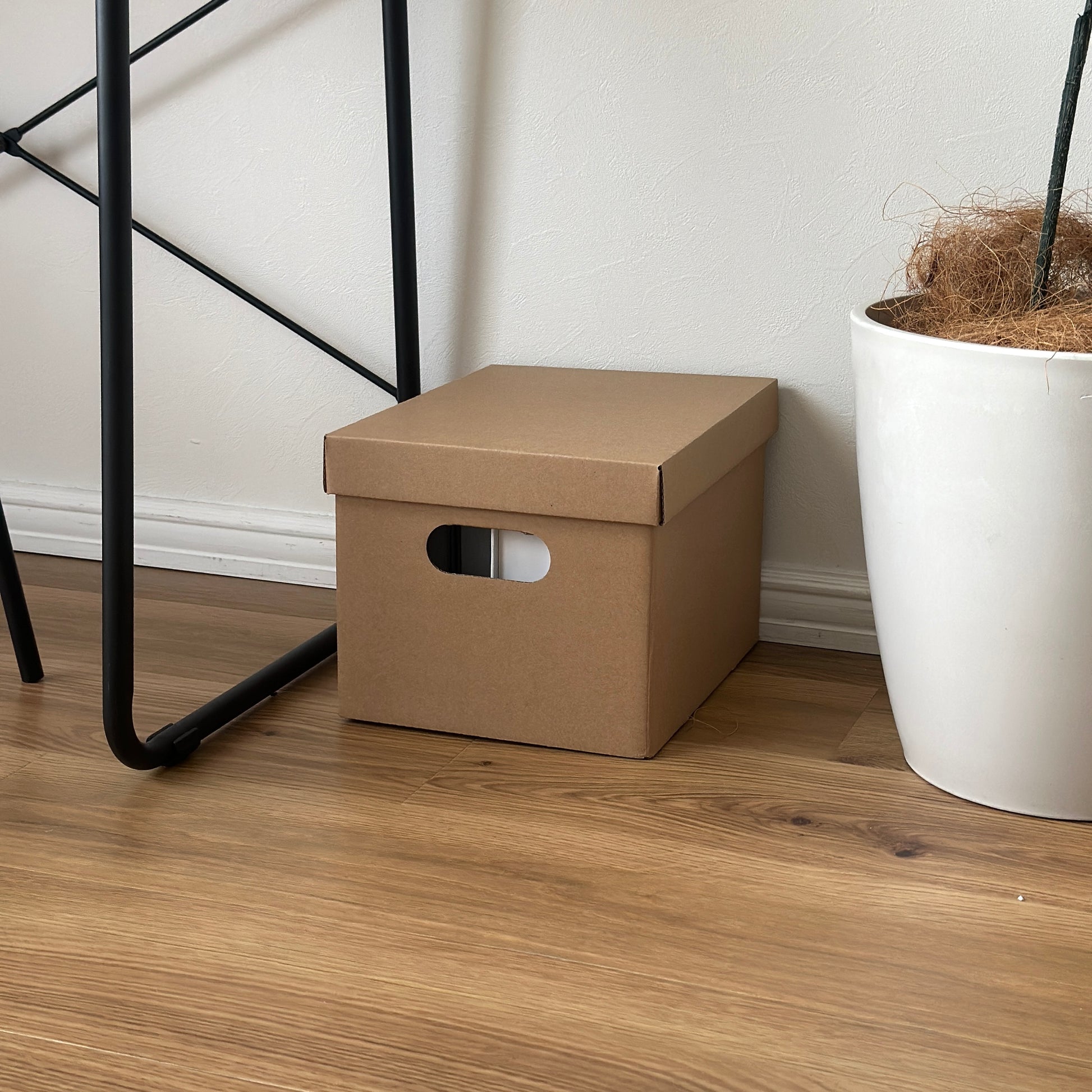 デスクの下に蓋付きのクラフトボックスが置かれている様子