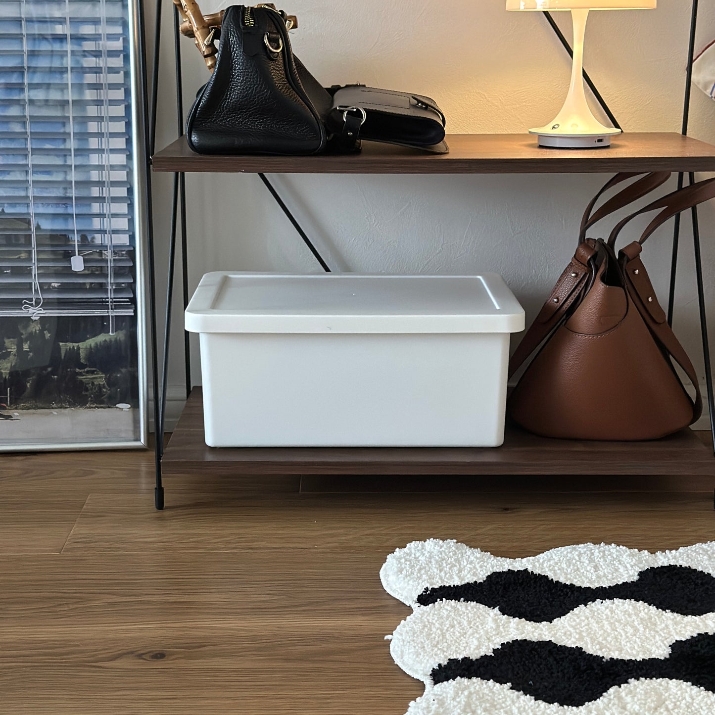 蓋付きのシンプルなプラスチックの収納ボックスが棚の中に収納されている様子