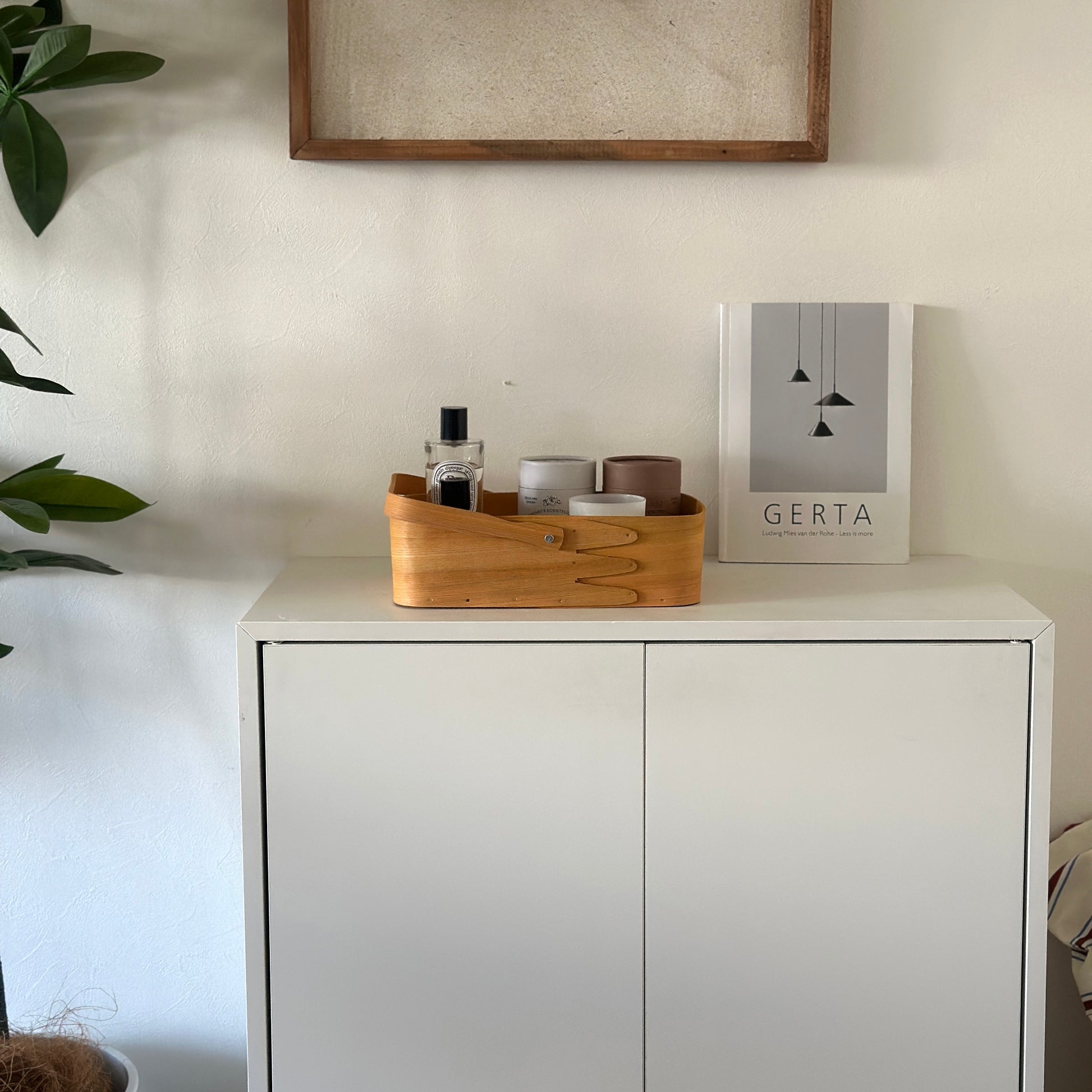 小物が収納されている取手付きのシェーカーボックスが棚の上に置かれている様子