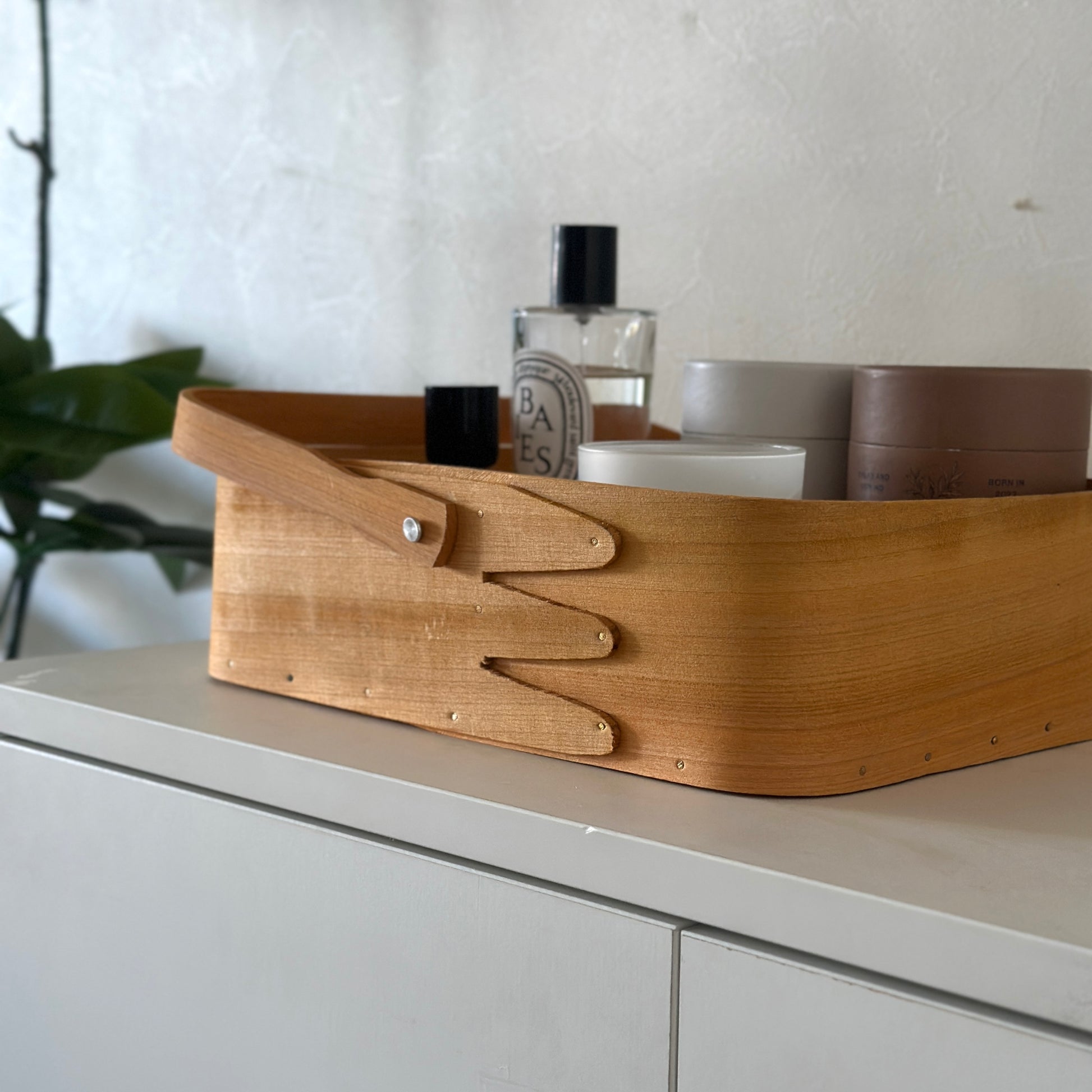 小物が収納されている取手付きのシェーカーボックスが棚の上に置かれている様子