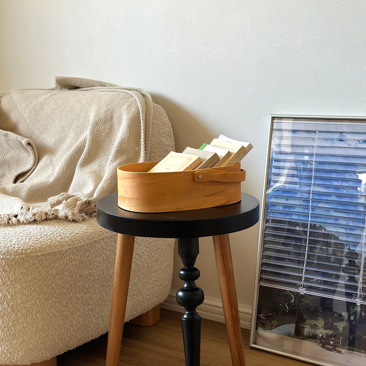 本が収納されている取手付きのシェーカーボックスがサイドテーブルの上に置かれている様子