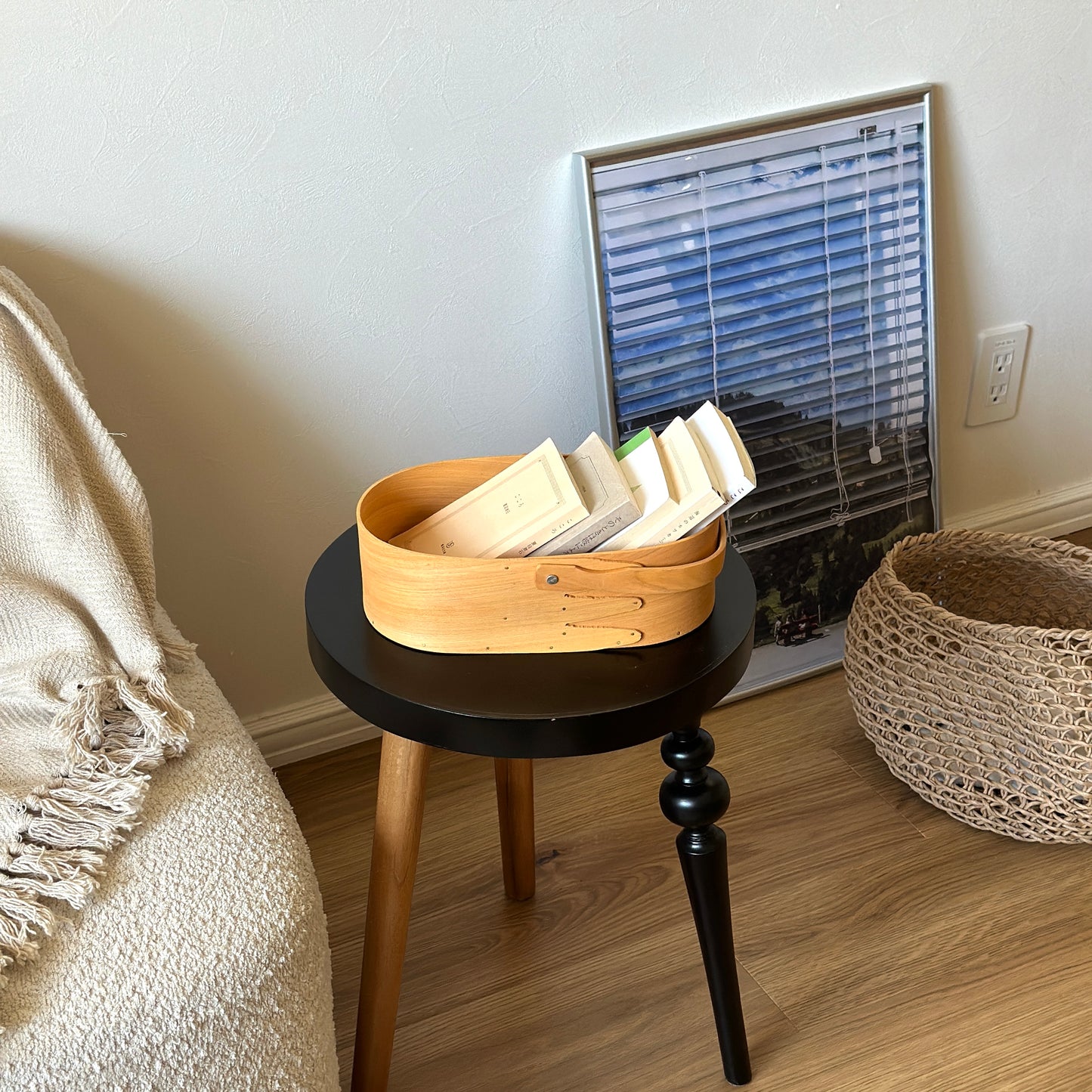 本が収納されている取手付きのシェーカーボックスがサイドテーブルの上に置かれている様子