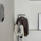 部屋の中で黒の回転式ポールハンガーに洋服が飾られている様子
