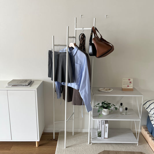部屋の中で折り畳めるスタイリッシュなパーテーションハンガーに洋服やバッグが飾ってある様子