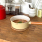 ラーメンが入った黄色の片手鍋がキッチンに置かれている様子
