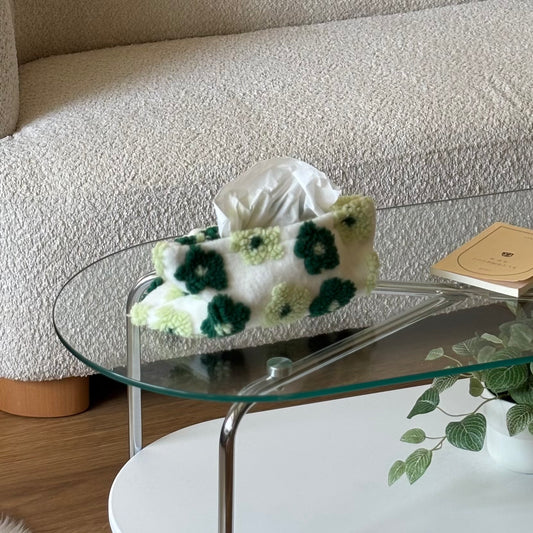 グリーンの花柄のティッシュケースをクリアなテーブルに置いている様子