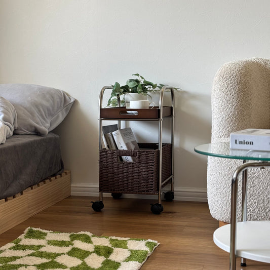 メッシュバスケットがついたウォルナットのワゴンをソファーとベッドの間に置いている様子