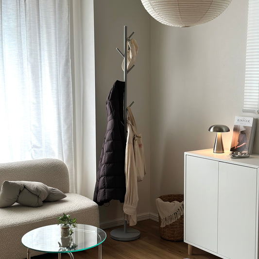 リビングに置かれたグレーのポールハンガーに帽子やバッグ、アウターが掛けられている様子