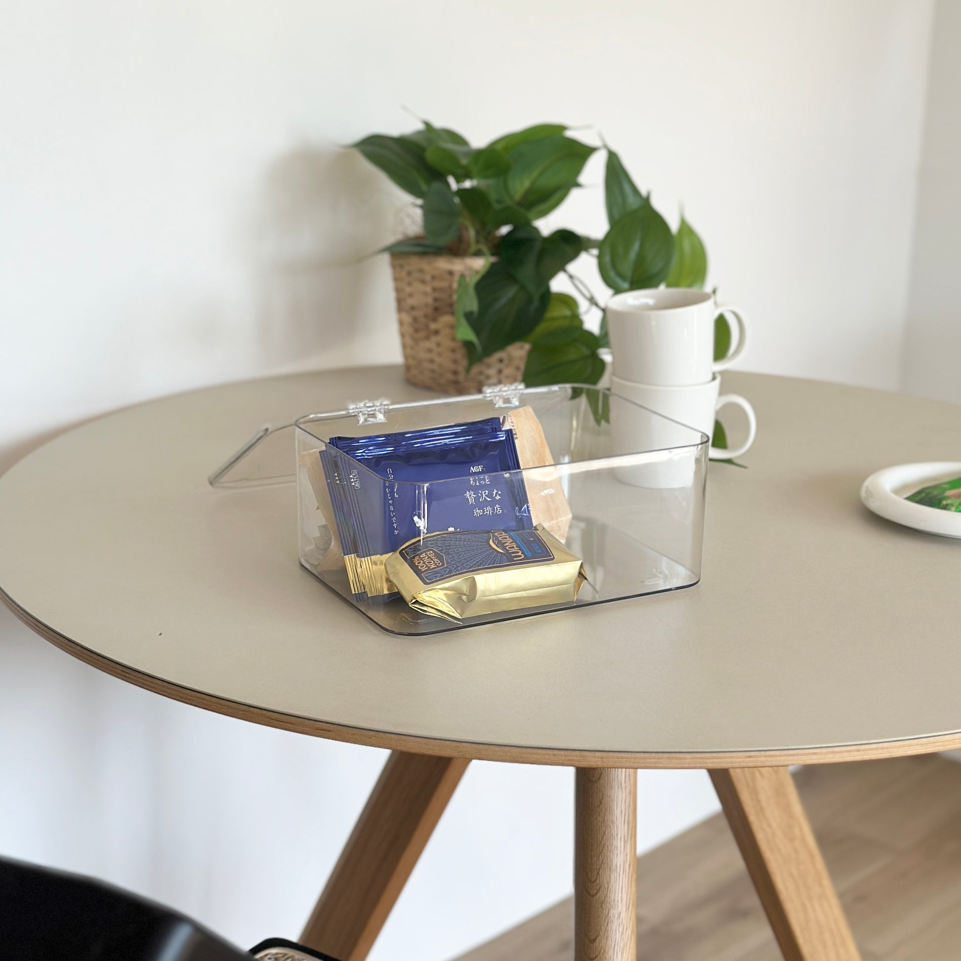 テーブルの上で透明のコーヒーセットが入ったボックスを広げているインテリア