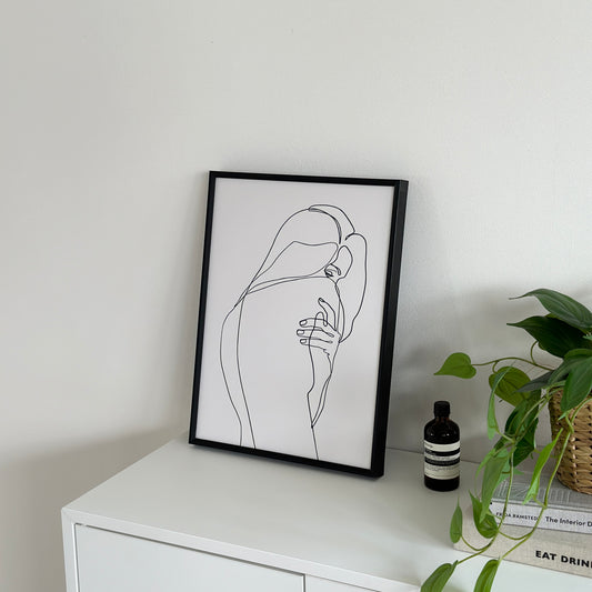 女性が振り向いた姿が描かれたラインアートが棚の上に置かれている