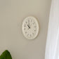 壁にかけられたフチがぽってりとした形のシンプルな掛け時計