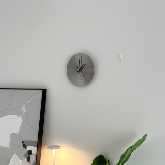 壁にかけられた文字盤がシルバーの掛け時計