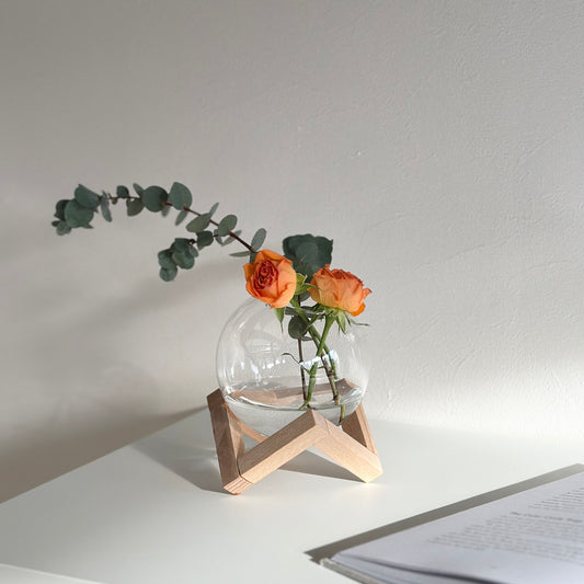 木製のスタンドとガラスの組み合わせのフラワーベースに花を飾っている様子