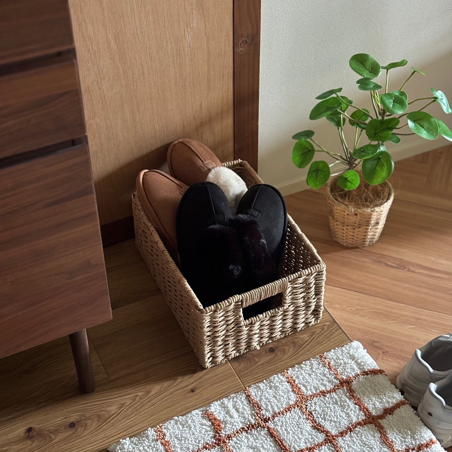 手編みの折り畳み式ペーパーコードバスケットの中にスリッパを入れて、玄関に置いている様子