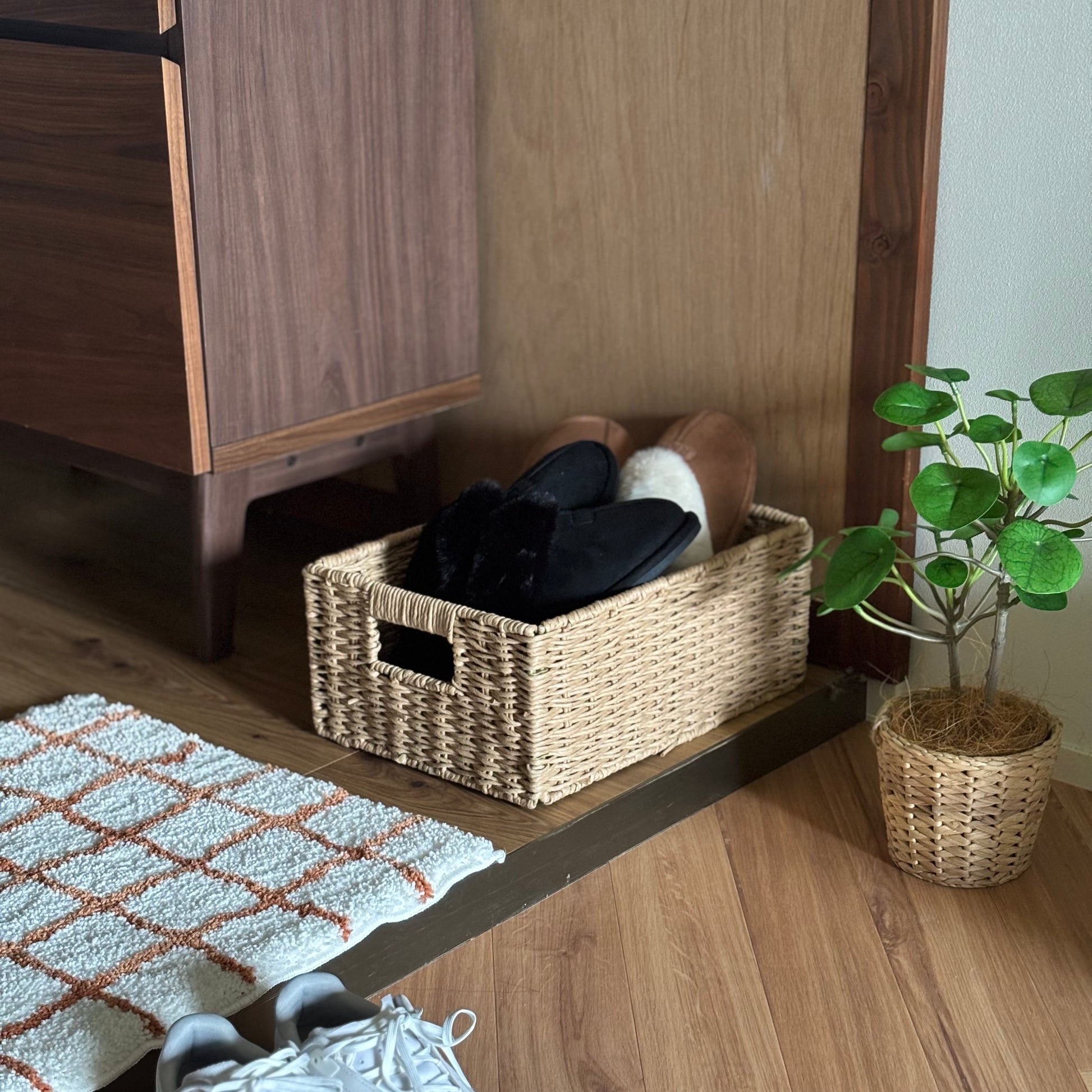 手編みの折り畳み式ペーパーコードバスケットの中にスリッパを入れて玄関に置いている様子